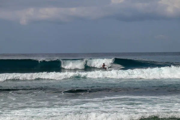 Joven en la ola. El Surfista sale de la tubería. Olas en Bali — Foto de Stock