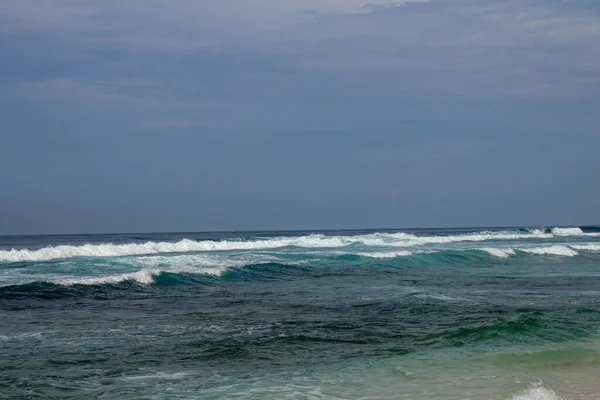 Big breaking wave with glowing green water and big white spray a