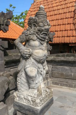 Endonezya, Bali 'deki Tanah Lot yakınlarındaki Batu Bolong Tapınağı' nda taş heykele yakın. Bir muhafız olarak Hindu tapınağının girişinde duran güzel detaylarla oyulmuş bir heykel. Bali kültürü.