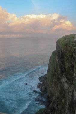 Uluwatu Tapınağı 'ndaki Iconic Ünlü Yeri' nin güzel panoramik manzarası, canlı bir yaz gündoğumu sırasında. Bali Adası 'ndaki Pura Luhur Uluwatu tapınağında inanılmaz manzaralar. Bulutlu, renkli bir gün batımı..