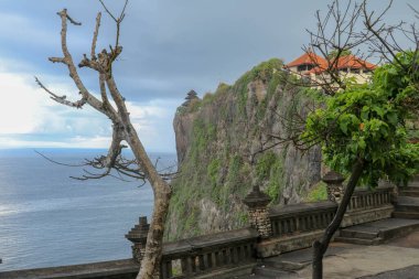 Endonezya 'nın Bali kentindeki Uluwatu uçurumunun manzarası. Uluwatu Tapınağı (Pura Luhur Uluwatu), Uluwatu 'da bulunan bir Hint tapınağıdır. Muhteşem konumu ile ünlüdür..