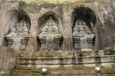 Udayana Hanedanlığı Kraliyet Mezarları. Gunung Kawi Tapınağı 'ndaki antik kraliyet mezarları. Cenaze kompleksi 11. yüzyılda taş uçurumlara oyulmuş kraliyet mezarları etrafında kurulmuştur. Bali, Endonezya.