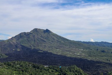 Volkan manzarası lav tarlaları, çam ağaçları, çiftlikler ve yamaçlardaki evler. Kintamani, Endonezya 'nın Bali kentindeki Gunung Batur Kaldera Duvarı' nın batı kıyısında yer alan bir köydür..