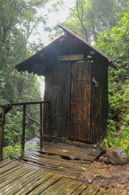 Tropikal ormanlarda odaları değişen ahşap bir kulübe. Sprey şelalesinin yanında, Banyumala. Endonezya 'daki Bali Adası ziyaretçileri için tahta ayaklıklarda bambu soyunma odası. Aour projesi için en iyi arkaplan.