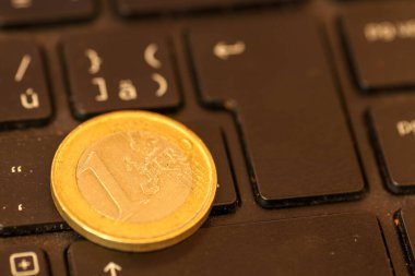 Avrupa sikkeleri dizüstü bilgisayarın klavyesinde. Kapatın, mesaj için yer açın. İnternet ya da çevrimiçi satın alma ödemeleri üzerinde çalışma kavramı. Laptop klavyesi ve 1 Euro madeni para.