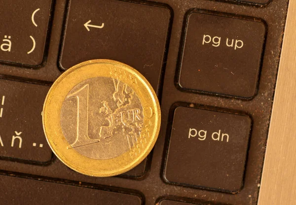 Euro coins lie on a laptop keyboard. Close up, space for text. Concept of working on the Internet or online payment for purchase. Laptop keyboard and coin 1 Euro.