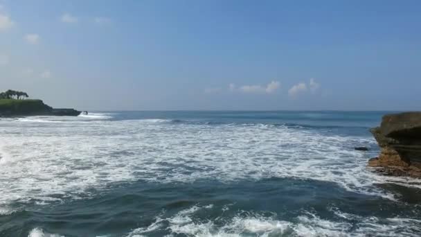 印度尼西亚巴厘岛著名的海上坦纳罗特神殿，蓝天飘扬，波涛汹涌 — 图库视频影像