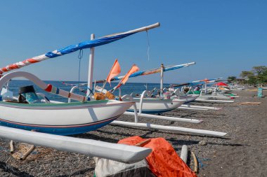 Endonezya 'nın Bali adası kıyısında. Güneşli bir günde güzel bir manzara. Geleneksel bale tekneleri, Jukung sahilde