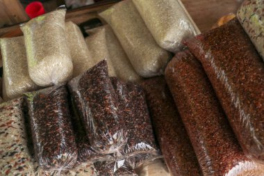 Plastik süpürge torbasında beş farklı pirinç türü. Kahverengi arka planda küçük plastik torbalarda çeşitli Groats 'lar. Pirinç ve yulaf ezmesi, karabuğday ve darı.