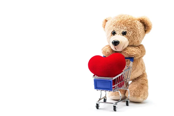 Teddy bear with heart shaped pillow in a cart — Stock Photo, Image