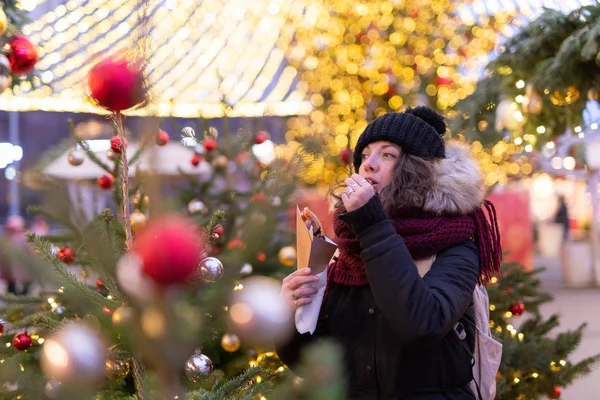 Lady eats Christmas cookies on the Moscow\'s biggest Christmas market