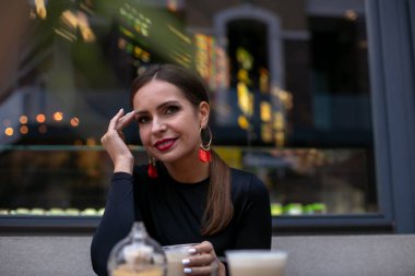 Bir Stre masasında oturan genç ve güzel bir kadının portresi.