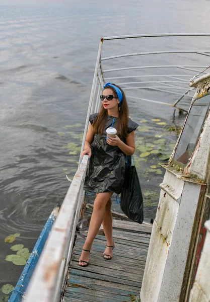 Retrato de uma jovem mulher em um vestido de sacos de lixo em umas costas — Fotografia de Stock