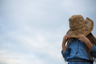horizontal photo of a six year old girl who pulled her hat over 