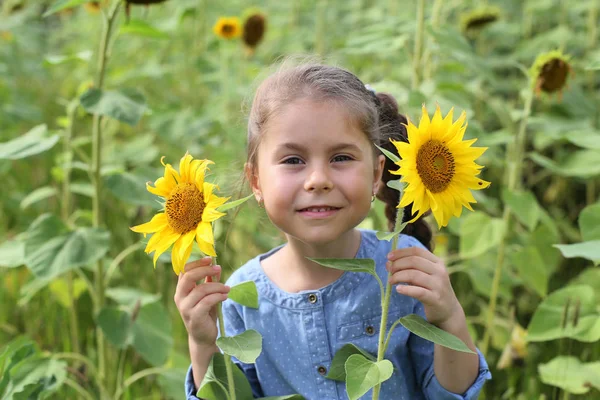 Horizontal photo of a six year old girl in a sunflower field wit — Stockfoto