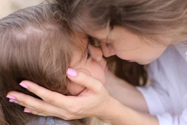 Mutter berührt das Gesicht ihrer kleinen Tochter — Stockfoto