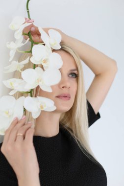 vertical photo close-up of a blonde with long hair in a black dr