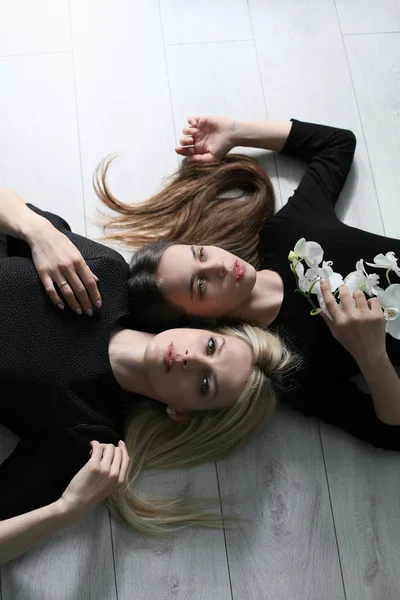 Foto vertical de meninas em vestidos pretos deitado no chão em t — Fotografia de Stock