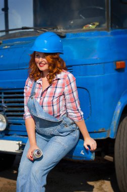 Kot pantolon giymiş kızıl saçlı Avrupalı bir kızın dikey fotoğrafı. 