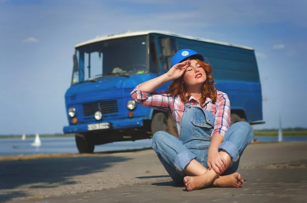 Foto de uma menina europeia de cabelos vermelhos em macacão jeans — Fotografia de Stock