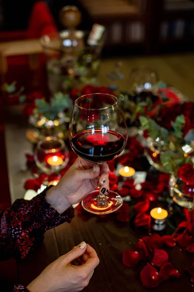 Pionowe zdjęcie samicy dłoni, która trzyma szklankę z czerwonym winem — Zdjęcie stockowe