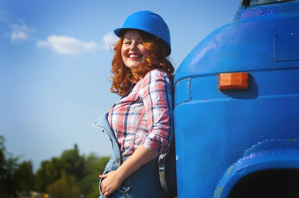 Photo d'une fille en salopette denim debout près d'un pare-chocs d'un tr — Photo