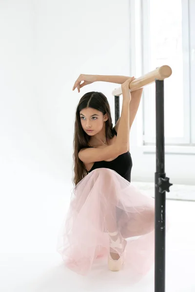 Foto vertical de uma bailarina jovem fazendo exercícios perto de um balle — Fotografia de Stock