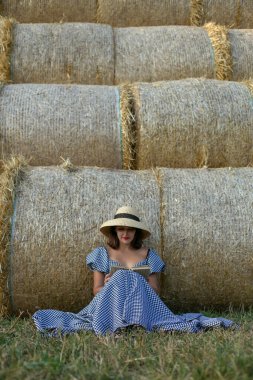 Arka planında kitap olan bir kadının dikey portresi.