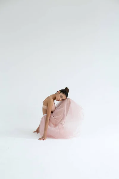 Vertikalt foto av en ballerina i en rosa tutu på en vit backgrou — Stockfoto