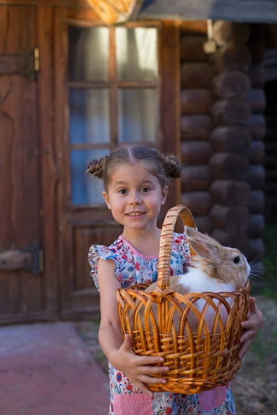 Foto vertical de una niña de seis años sosteniendo una cesta con una ra —  Fotos de Stock