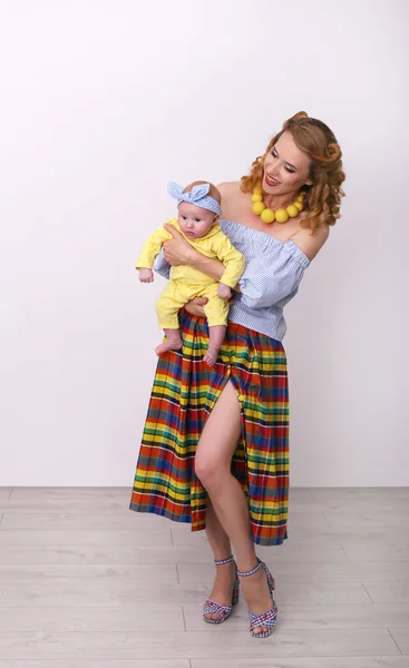 Vertical pin-up photo of a young pretty woman with a baby in her — Stock Photo, Image
