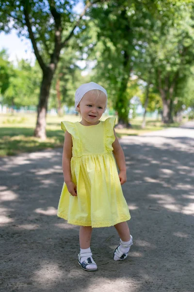 Vertical photo of a girl in a summer dress who stands on a path — Stock Photo, Image