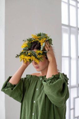 Kız kafasına çelenk takıyor.