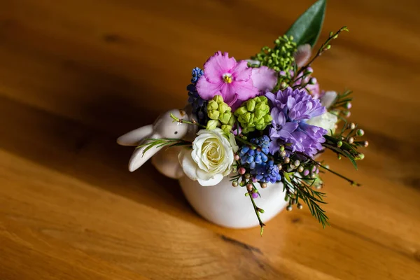 五彩斑斓的花朵矗立在一个白色的粘土罐子里 上面有一只东方兔子 — 图库照片