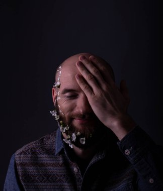 Genç yakışıklı adam gözleri kapalı gülümsüyor.