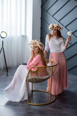 Siyah beyaz bir stüdyoda kameraya poz veren mutlu kızlar.