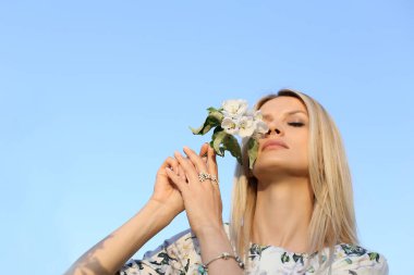 Genç ve güzel Avrupalı kadın baharın ve açık gökyüzünün tadını çıkarıyor.