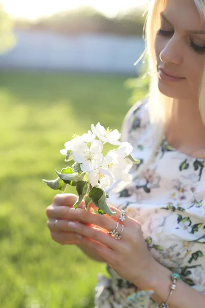Loira Vestido Flor Mantém Flor Maçã Suas Mãos Gentilmente Olha — Fotografia de Stock