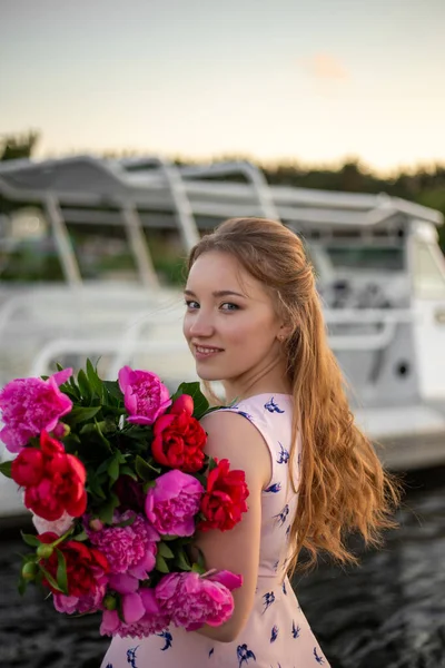 Uśmiechnięta Dziewczyna Bukietem Jasnych Piwonii Stoi Tle Białego Jachtu — Zdjęcie stockowe