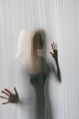 Genç, narin, güzel kadın elleri şeffaf bardağa dayanıyor.