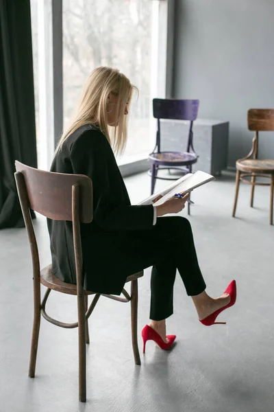 Mooi Blond Zit Een Stoel Een Half Lege Kamer Bij — Stockfoto