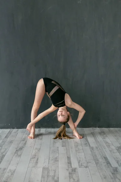 Little Gymnast Performs Tilt Dark Gray Wall — Stock Photo, Image