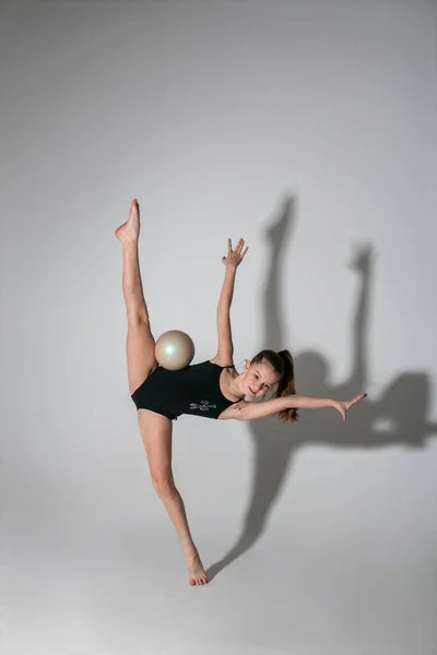 little gymnast in black tights at the time of the exercise with the ball