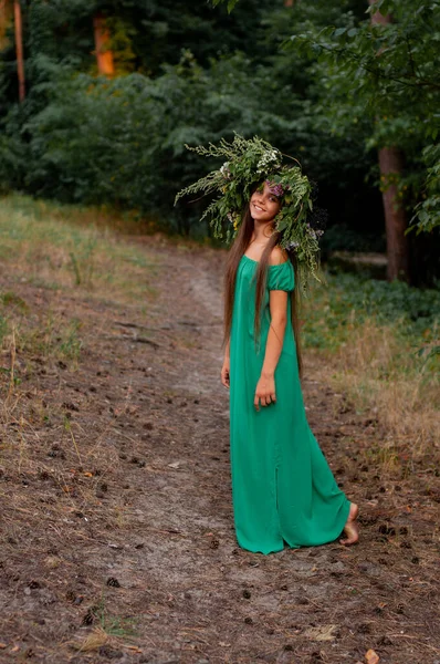 Boso Uśmiechnięta Dziewczyna Długiej Zielonej Sukience Wieńcem Głowie Stoi Leśnej — Zdjęcie stockowe