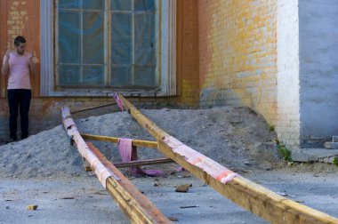 Genç adam terk edilmiş eski bir binanın yanında duruyor.