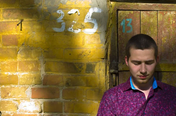 Junger Trauriger Kerl Steht Auf Dem Hintergrund Eines Alten Backsteingebäudes — Stockfoto