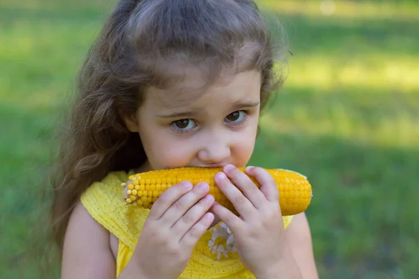 Cute Curly Baby Eats Corn Outdoors — Stock Photo, Image