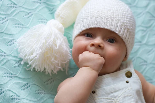 Das Baby Weißer Hose Und Weißer Strickmütze Mit Bommel Liegt — Stockfoto