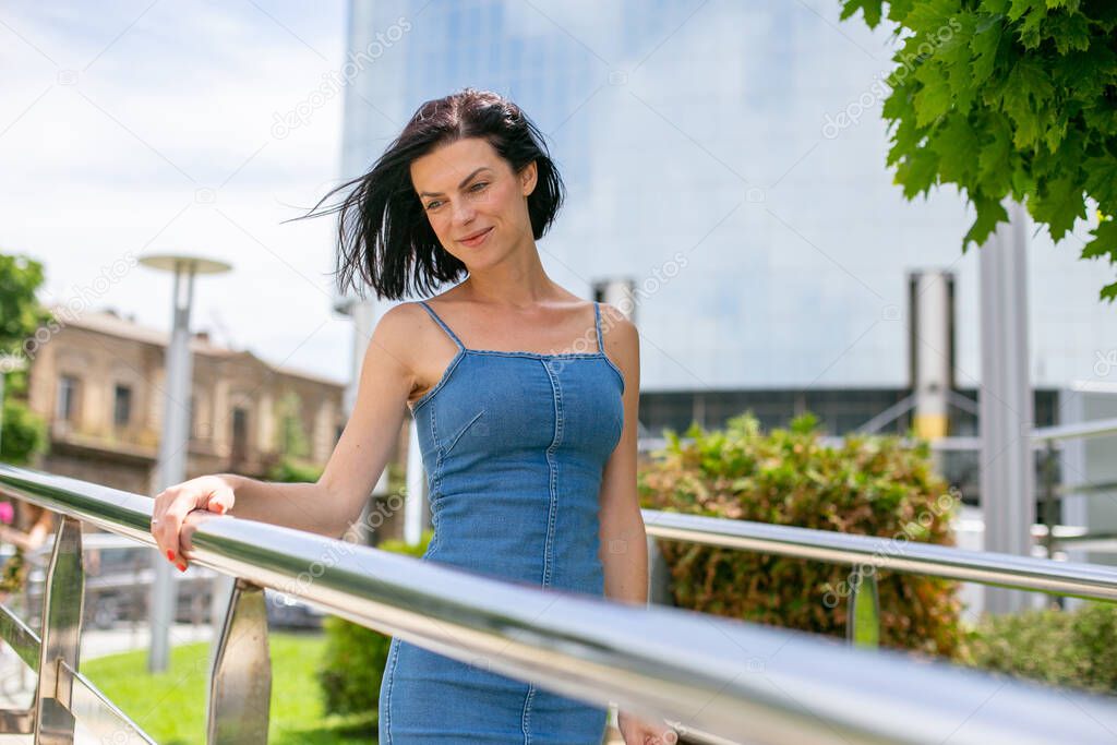 cute young woman walks on a modern bridge in the city