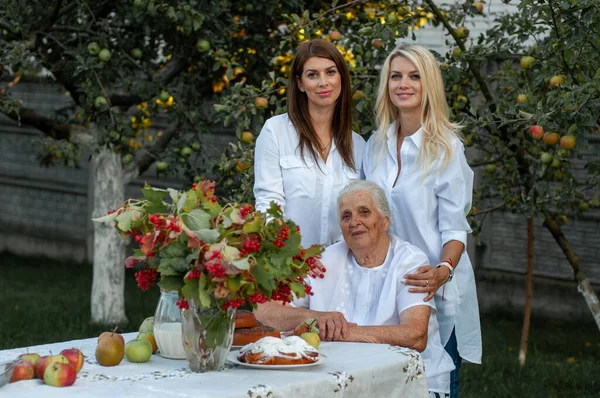 Avó Senta Uma Mesa Seu Jardim Seus Dois Adoráveis Netas — Fotografia de Stock